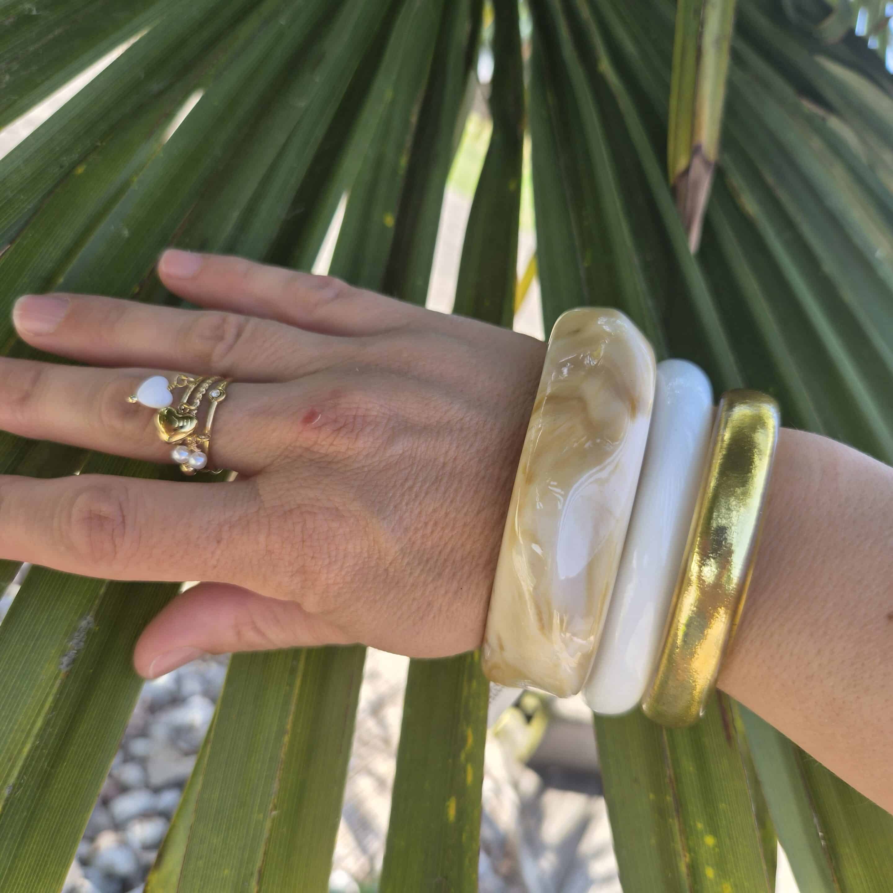 bracelet en résine blanc porté en combo avec un bracelet bouddhiste doré large et un bracelet en résine en forme géométrique marbré. By Créa'Lise en Vendée!