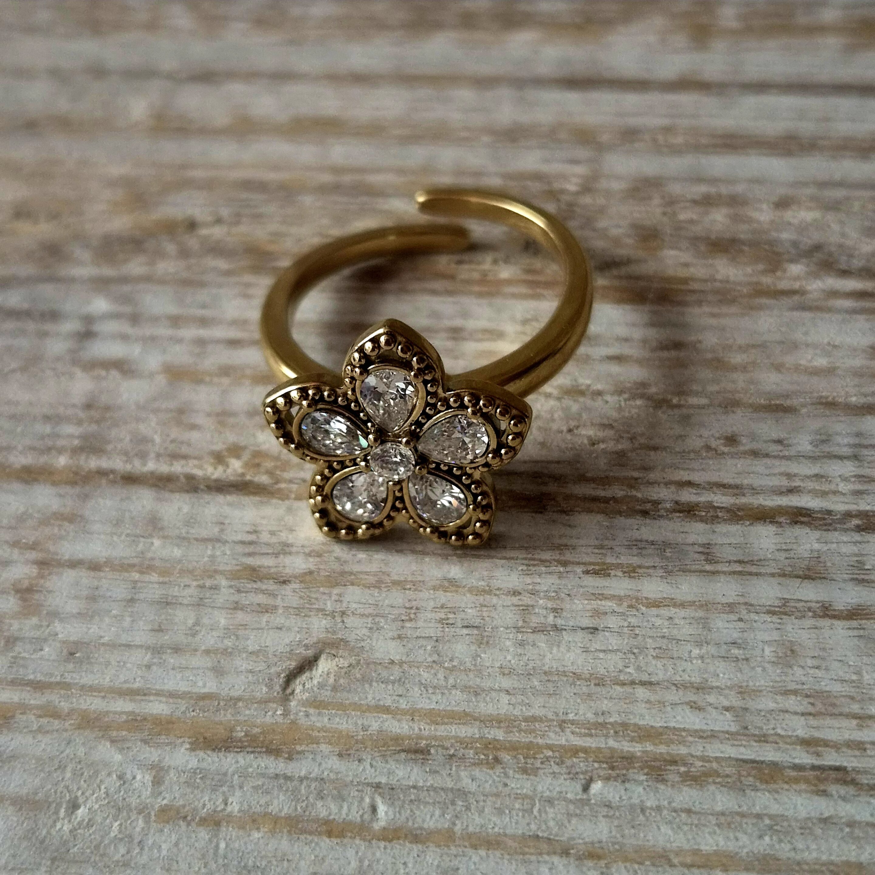 bague anti stress dorée fleur avec strass posée